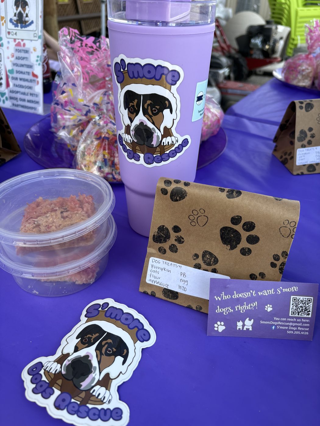 S’more Dogs Rescue table with dog treats, stickers, and branding