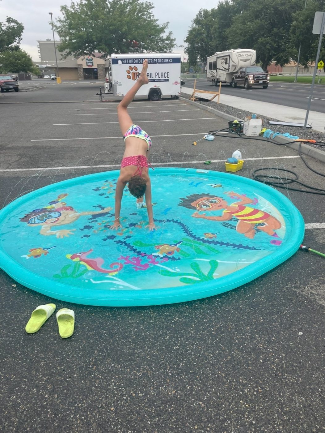 Kids cooling off in the splash pool after helping at a car wash
